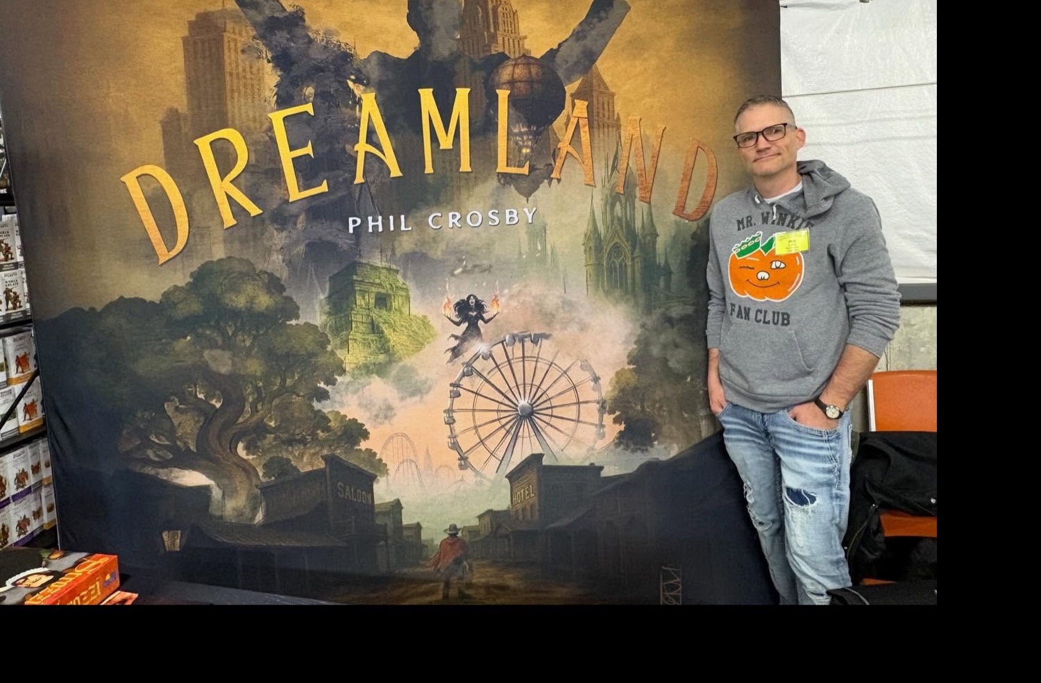Phil Crosby standing beside the full-size DreamLand banner at his Cincycon booth